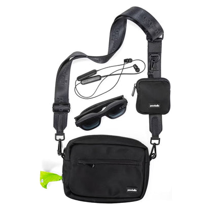 The Pawbella Crossbody Dog Walking Bag in black is shown with a matching small pouch, sunglasses, and wireless earphones on a white background. It features a zipper pocket, neon green tag, and is ideal for travel or everyday use in Australia.