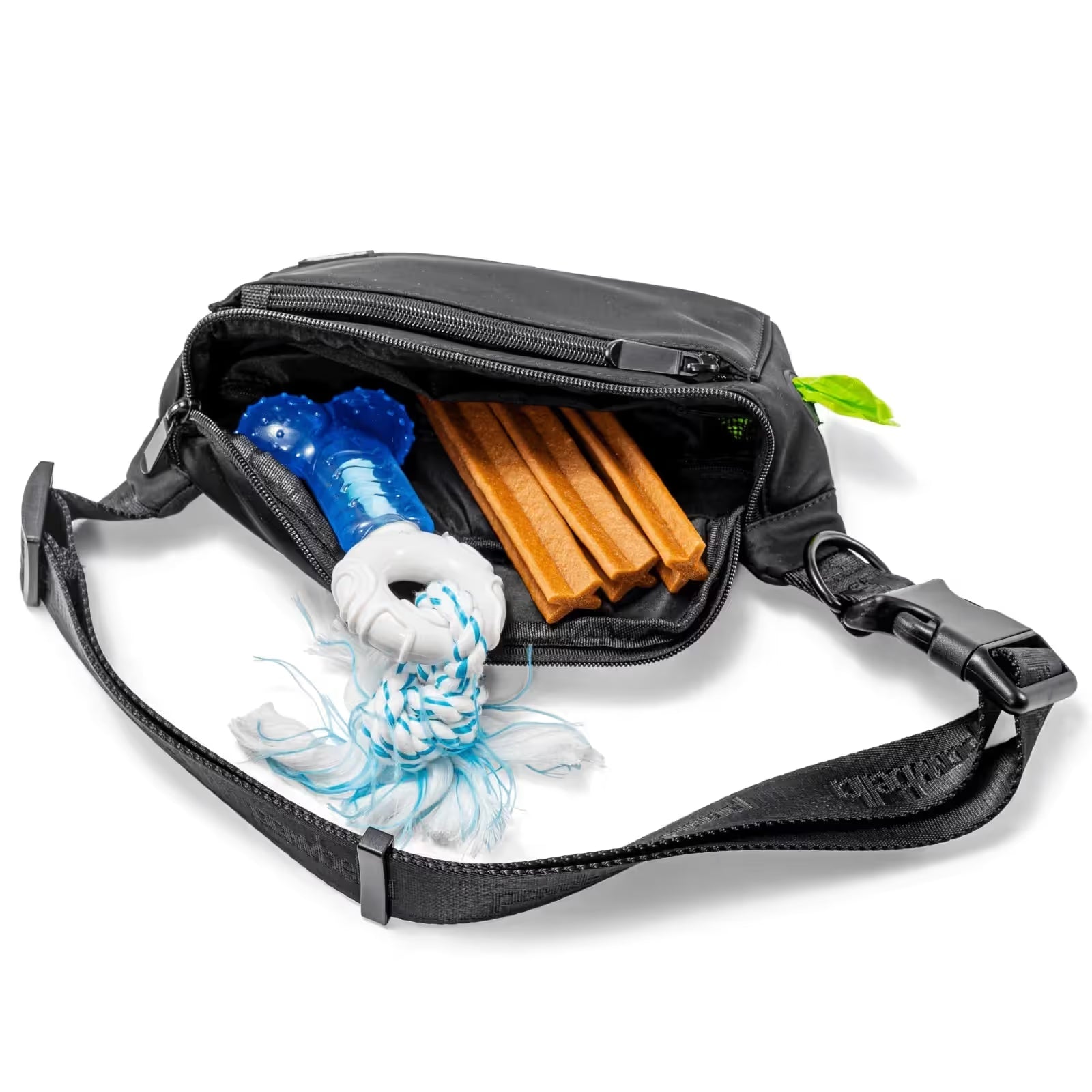 A Pawbella Dog Walking Bum Bag in black is unzipped to reveal a blue dog toy with white rope and three brown chew sticks inside, all shown on a white background.