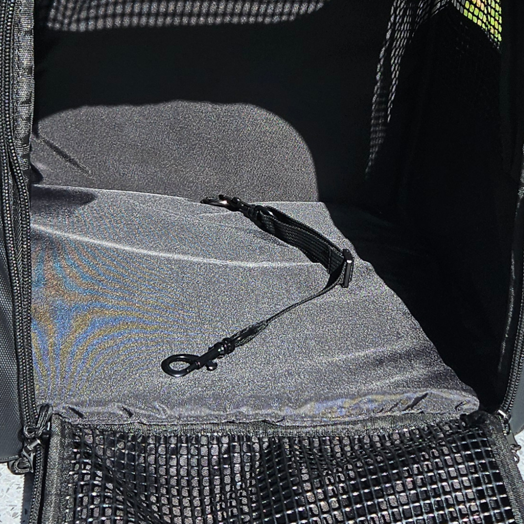 Close-up view of the safety tether inside a black Pawbella pet backpack, emphasizing the secure attachment feature for pets.