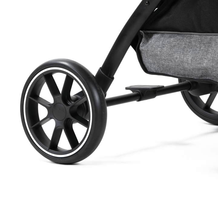 Close-up of a durable black wheel on a pet stroller, showcasing its sleek design and smooth mobility features on a grey fabric base.